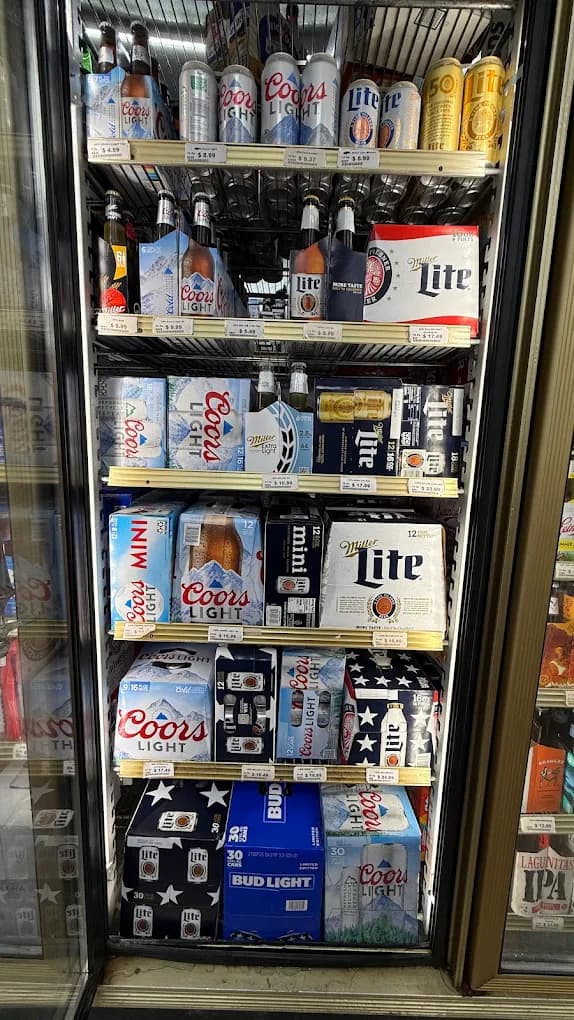 A beer cooler full of Coors Light, Miller Lite, and Bud Light cases