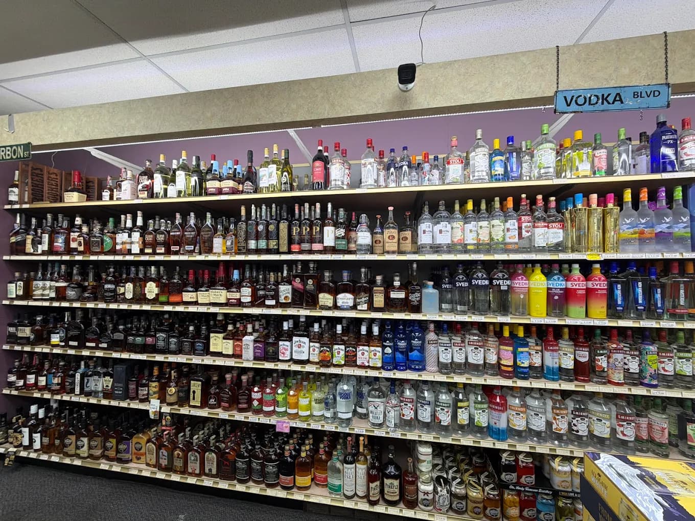 A full wall of bourbon and whiskey on one side and vodka on the other